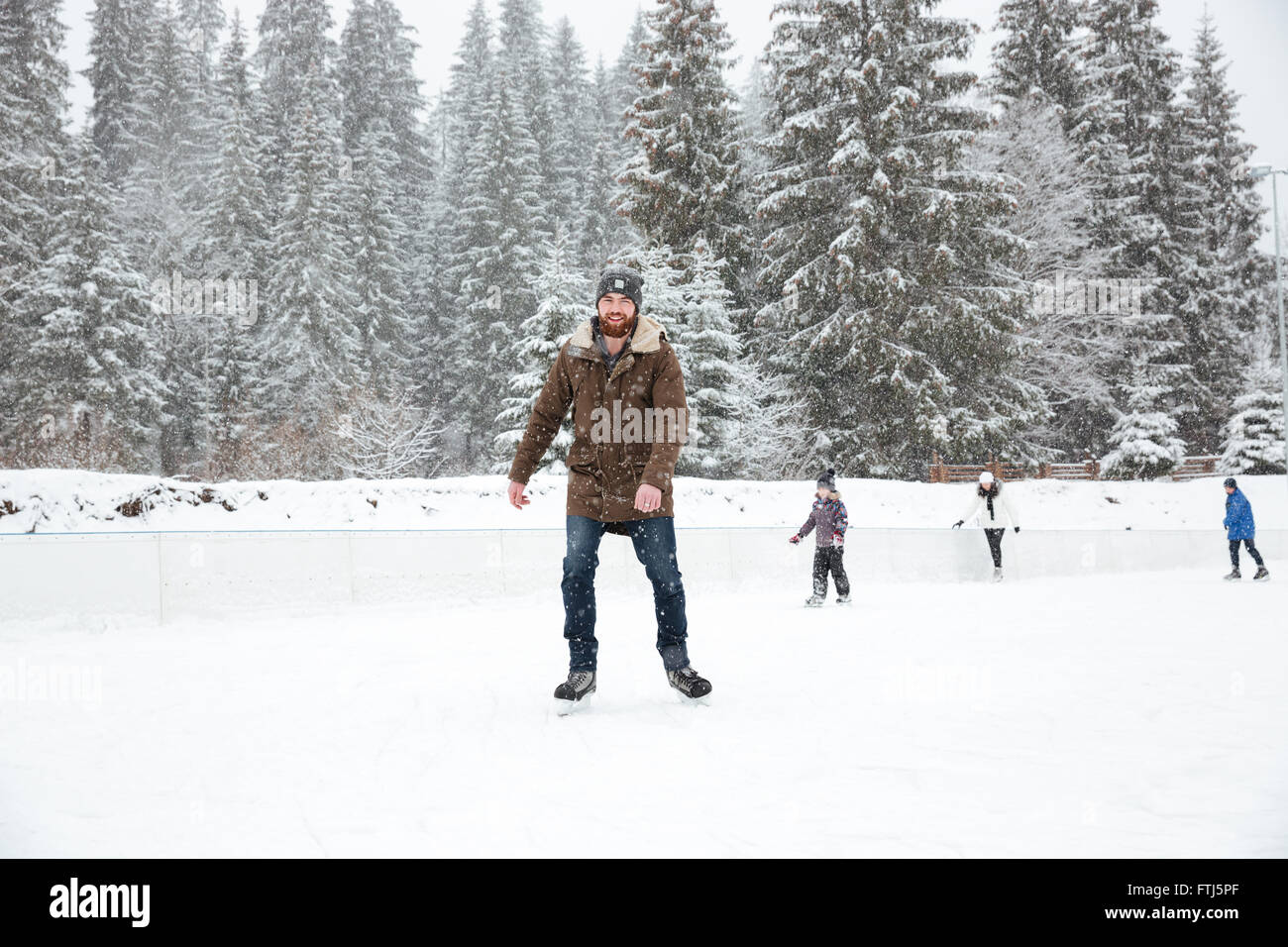 Porträt von ein glücklicher junger Mann Eislaufen im freien Stockfoto