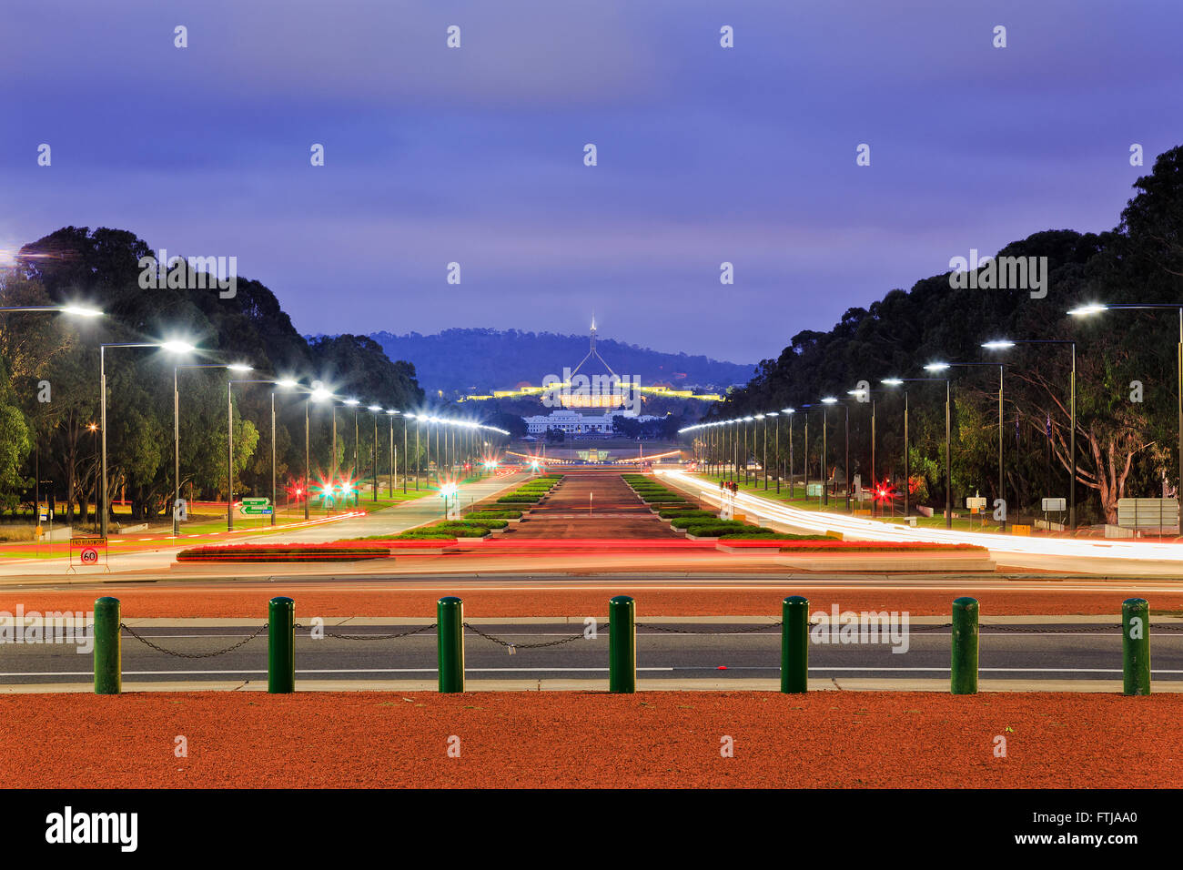 große beleuchtete Anzac Parade in Canberra von Kriegerdenkmal gegenüber alten und neuen australischen Parlamenten bei Sonnenaufgang Stockfoto