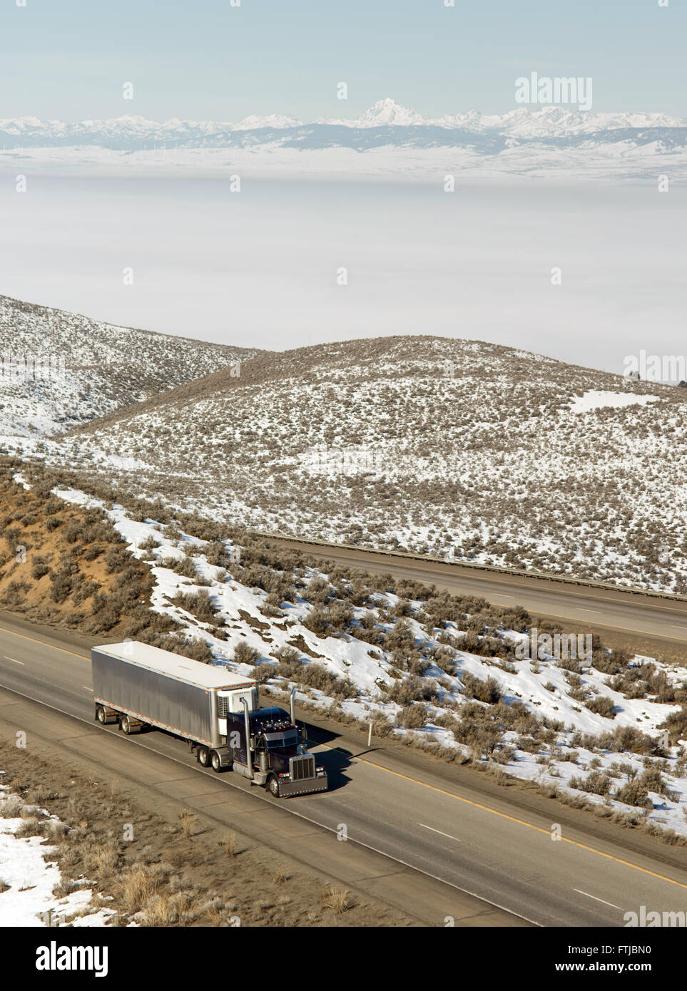 Big Rig Trucker Semi Truck fährt Interstate Kaskadenkette Hintergrund Stockfoto