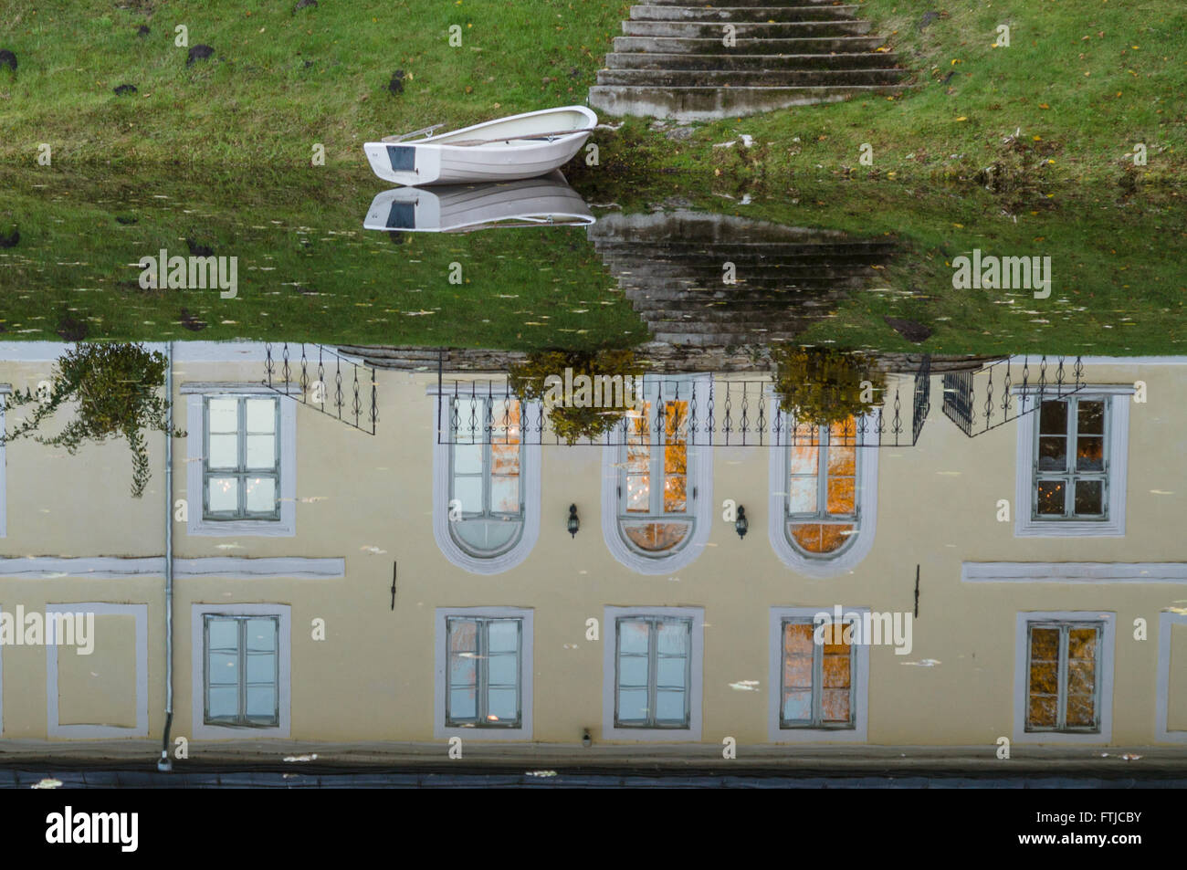 Herrenhaus Reflexion über Wasser Teich und leeres Boot Stockfoto