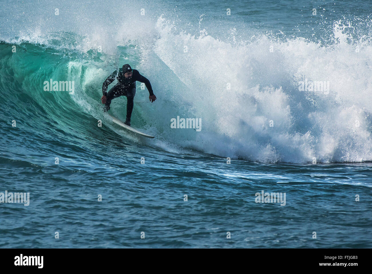 Ein Surfer auf einer Welle am Hafendamm in Cornwall. Stockfoto
