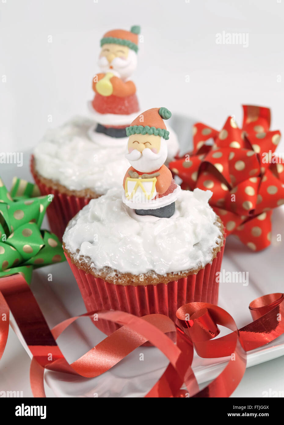 Weihnachten-Cupcakes mit traditionellen Dekorationen und Schlagsahne Stockfoto
