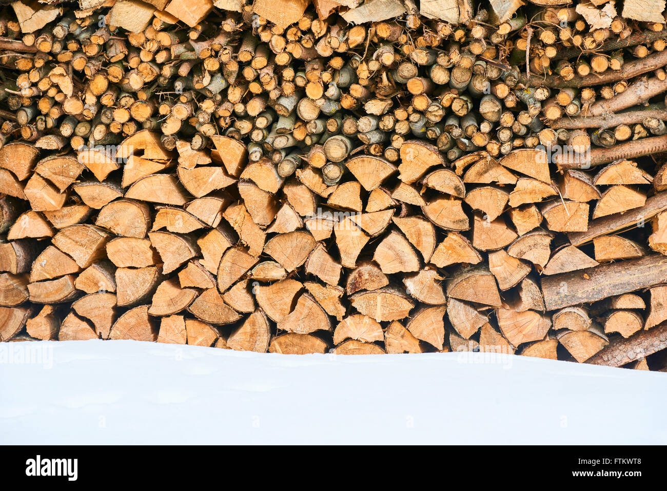 Brennholz gestapelt im Winter. Holz-Haufen mit Schnee für Brennholz gestapelt Stockfoto