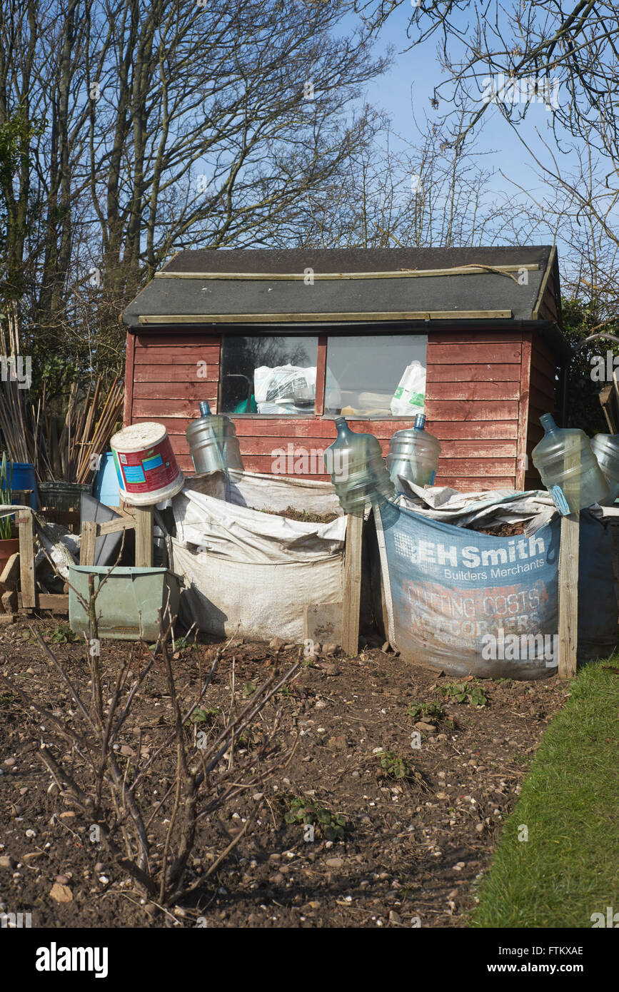 Zwei große Taschen von Kompost vor ein Gartenhäuschen in einer städtischen Zuteilung in den West Midlands im zeitigen Frühjahr Stockfoto