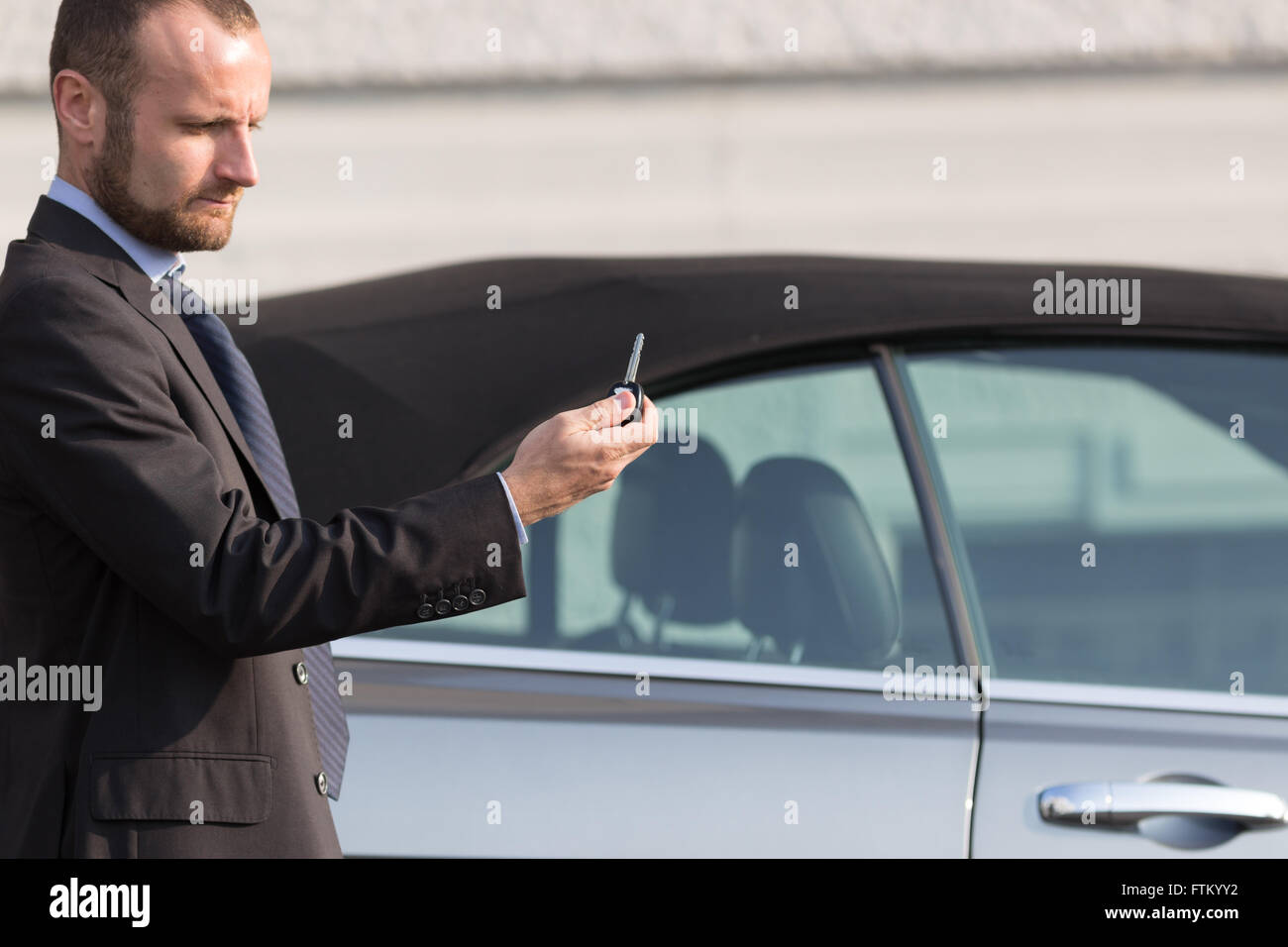 Geschäftsmann mit seinem Luxusauto Stockfoto