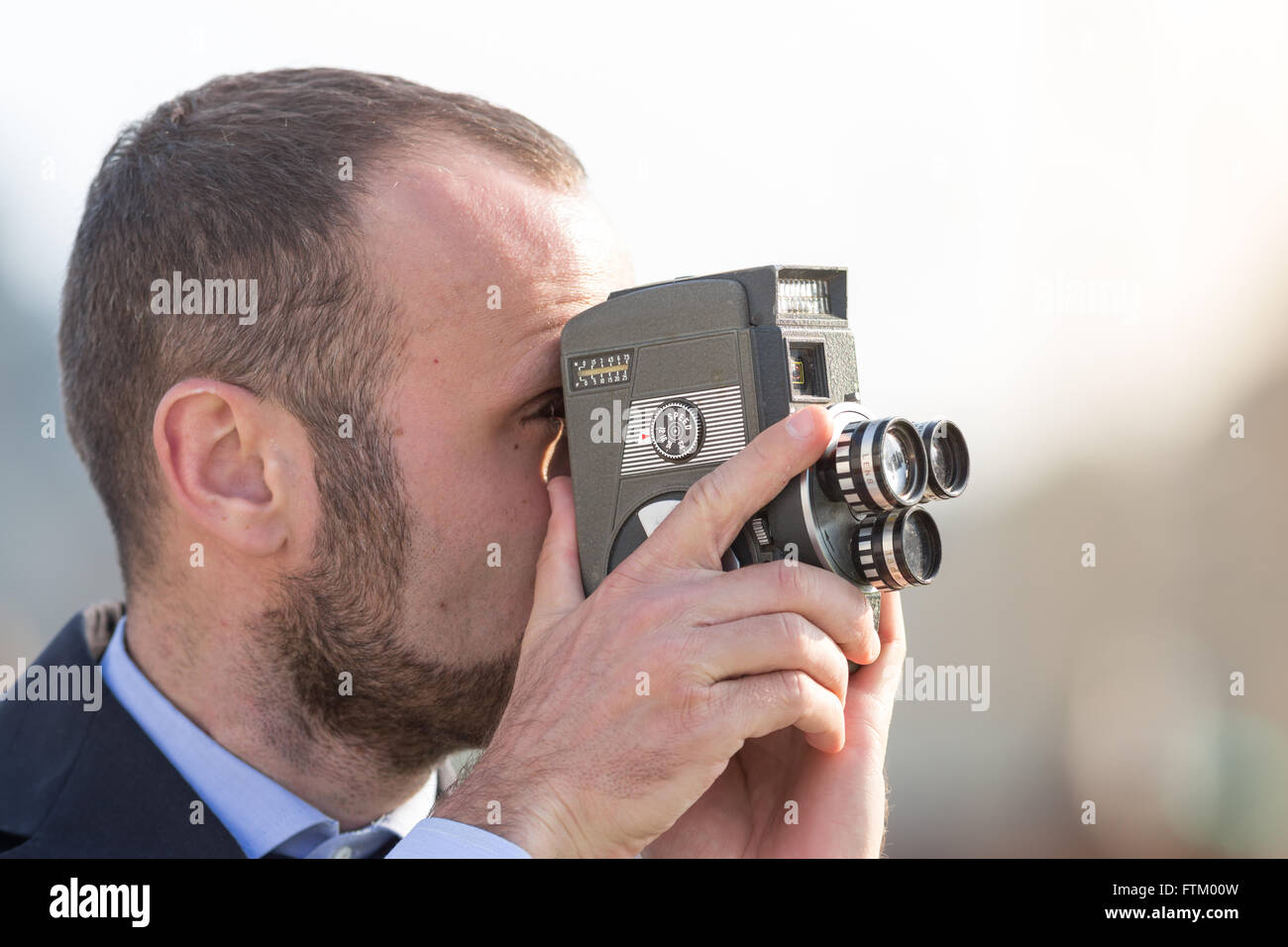 Geschäftsmann mit einer Vintage Filmkamera, keine Logos auf der Kamera im freien Stockfoto