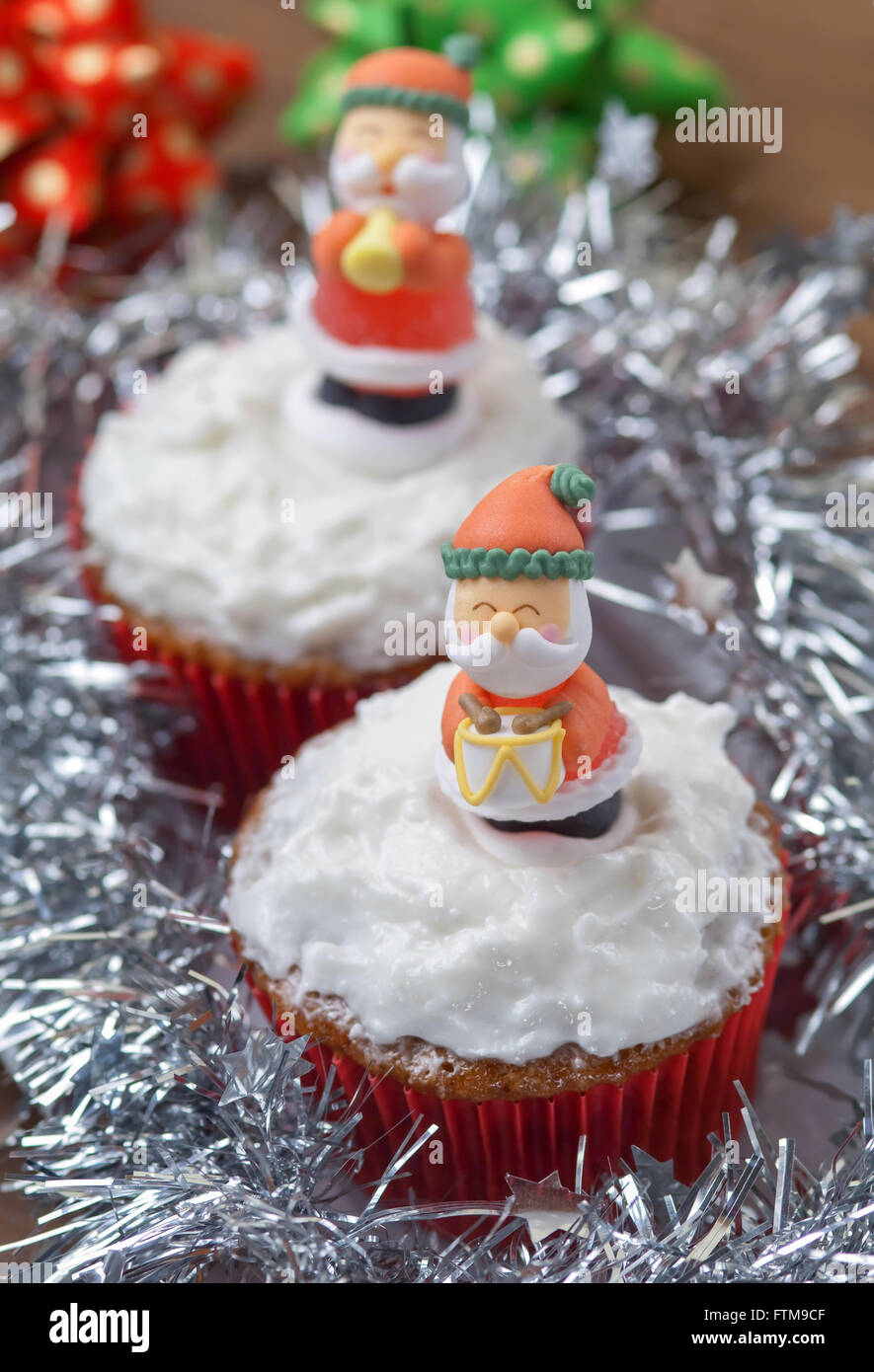 Weihnachten-Cupcakes mit traditionellen Dekorationen und Schlagsahne Stockfoto