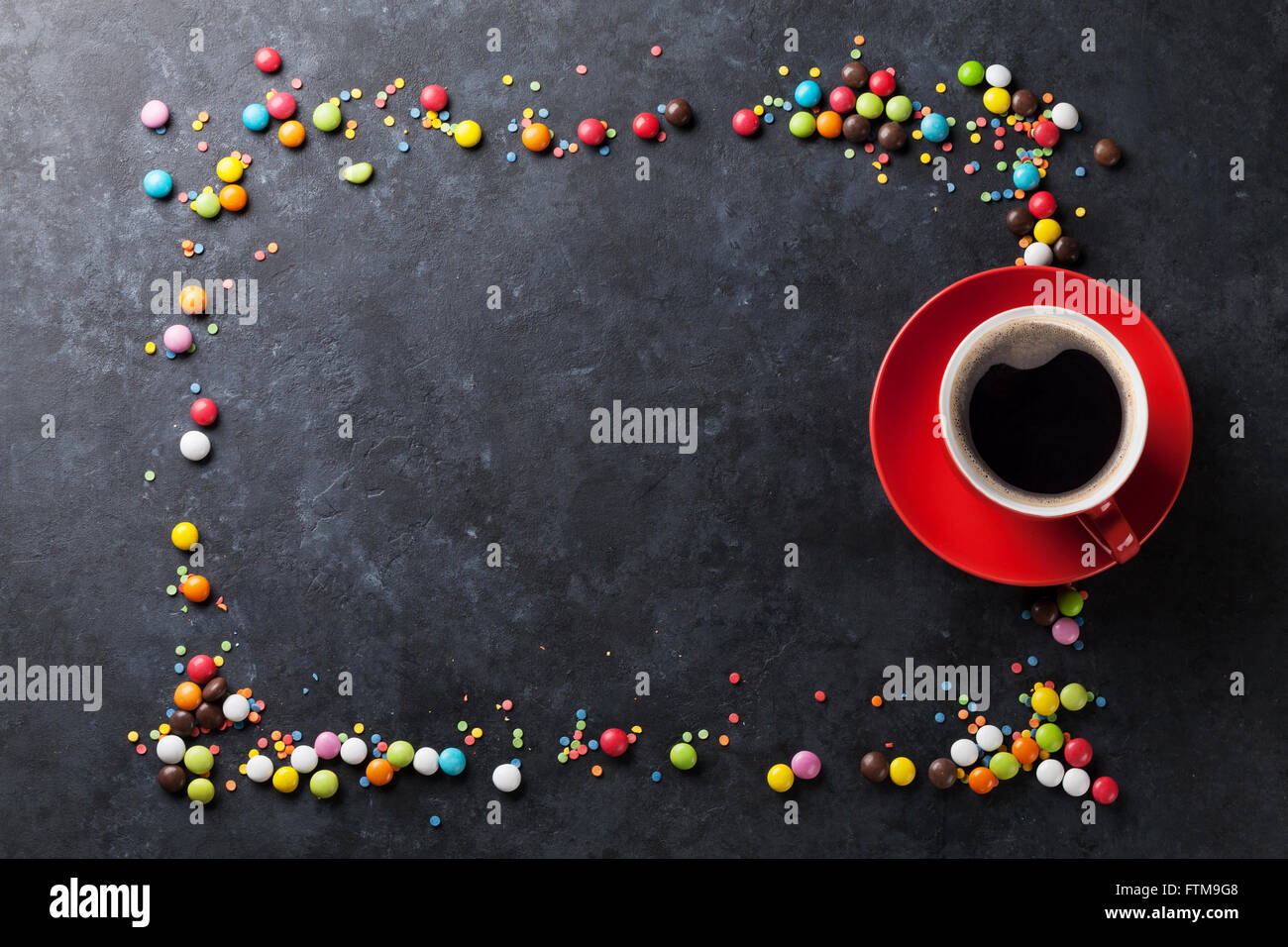 Bunte Bonbons Rahmen und Kaffee Tasse auf Stein Hintergrund. Draufsicht mit Textfreiraum Stockfoto
