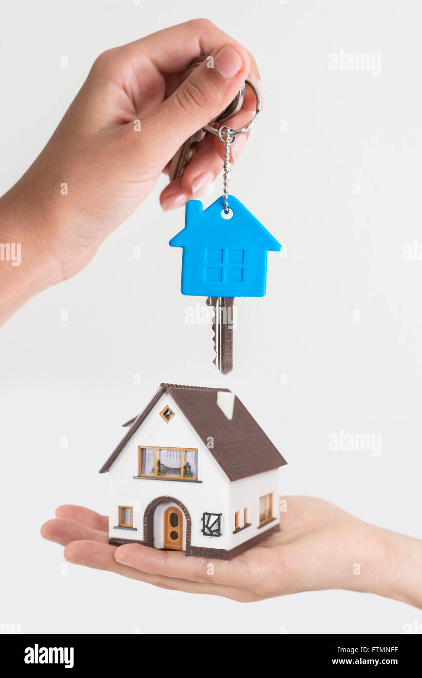 Immobilienmakler mit Hausmodell und Schlüssel Stockfoto