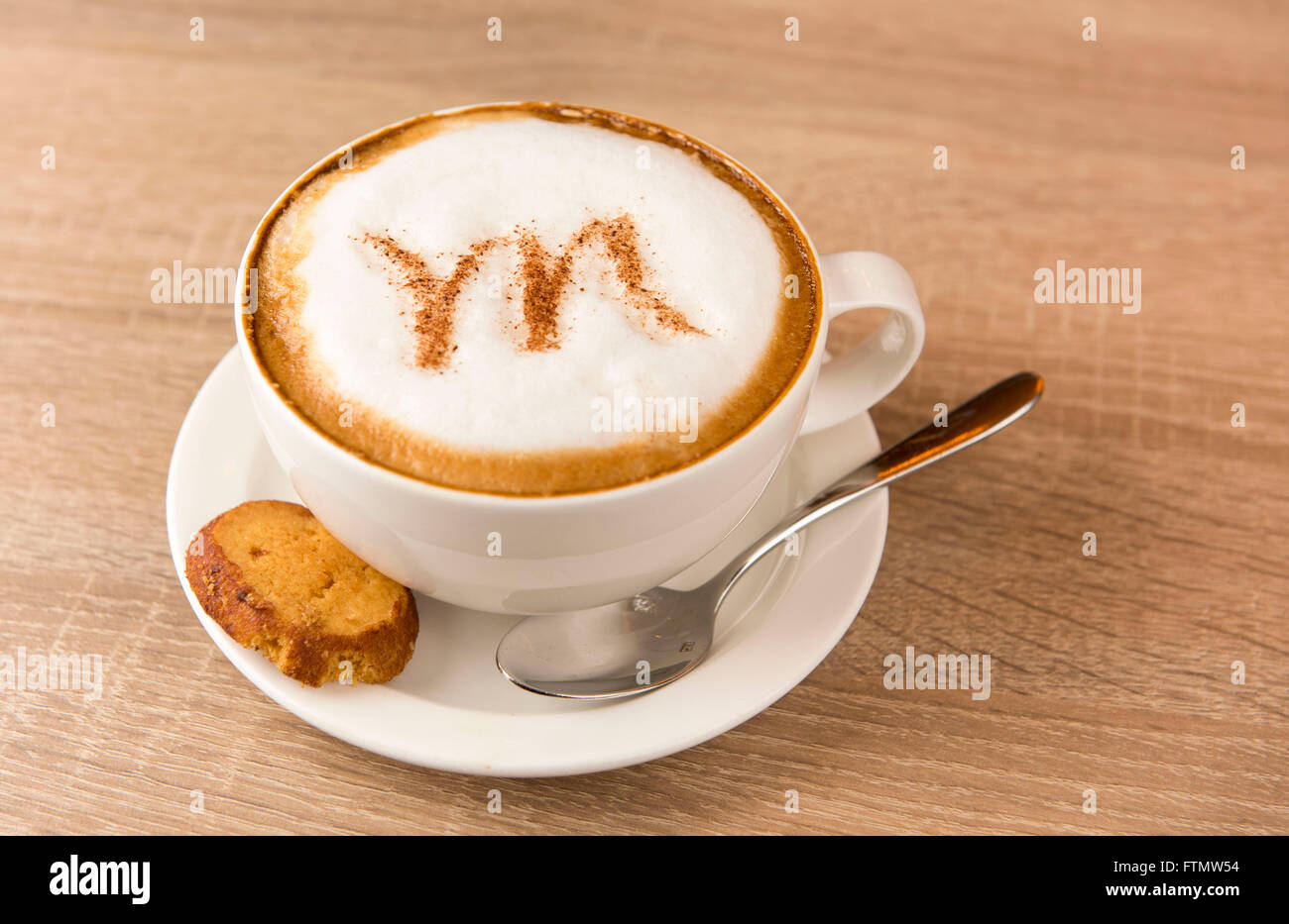 Ein Kaffee-Cappuccino-Latte mit einem Brief M in den Milchschaum geschrieben. Stockfoto