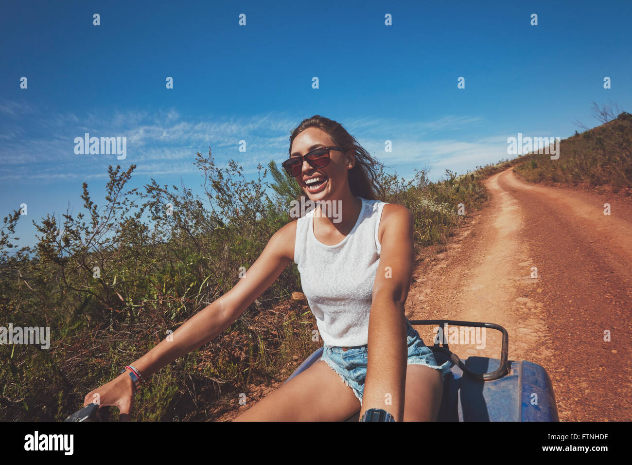 Junge Frau mit Quad begeistert. Glückliche junge Autofahrerin all-Terrain-Fahrzeug in der Natur. Stockfoto