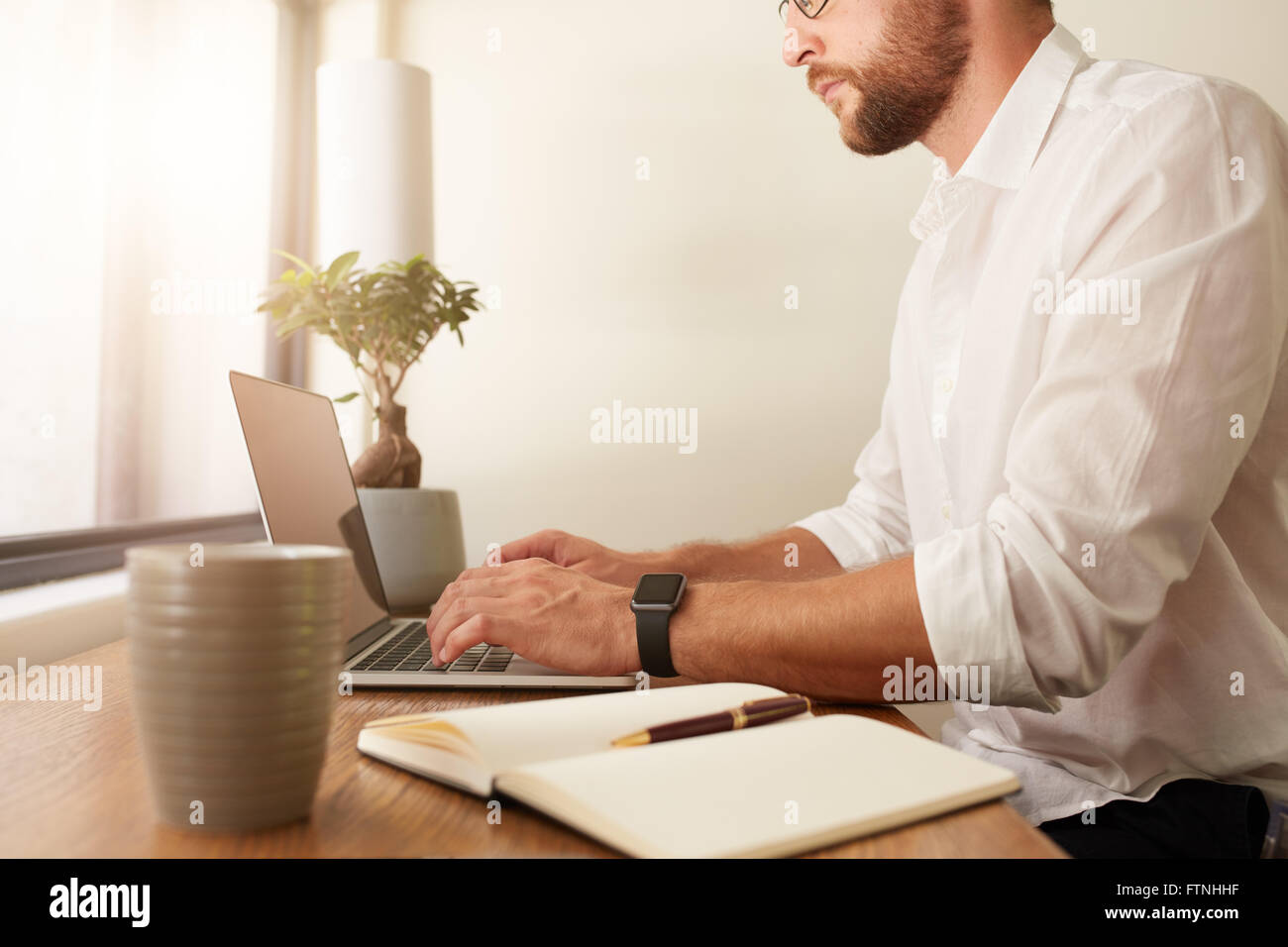 Bild der Geschäftsmann auf Laptop zugeschnitten. Mann, der vom home-Office arbeitet. Stockfoto