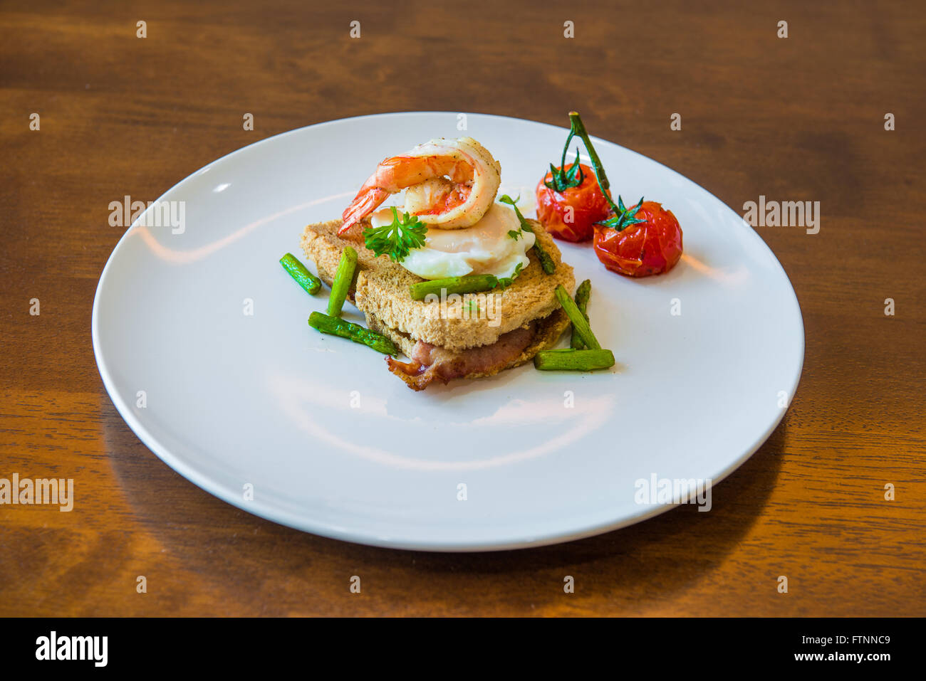 Sandwich mit pochiertem Ei, Parmaschinken und Tomaten Stockfoto