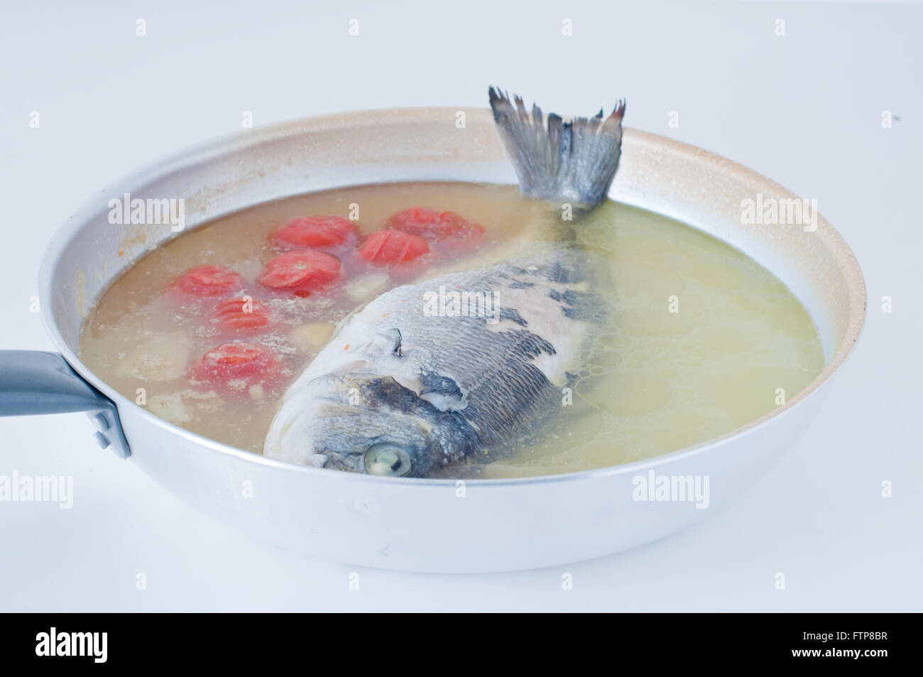 Brassen Fisch gekocht in verrückten Wasser, typisches Rezept Süditalien mit Meerwasser, Tomaten, Zwiebeln und Knoblauch, Italien Stockfoto