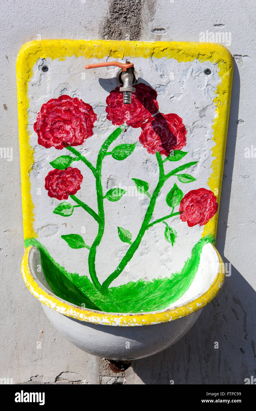 Altes Eisenwaschbecken an der Wand mit Blumenmotiv rote Rose, Waschbecken Stockfoto