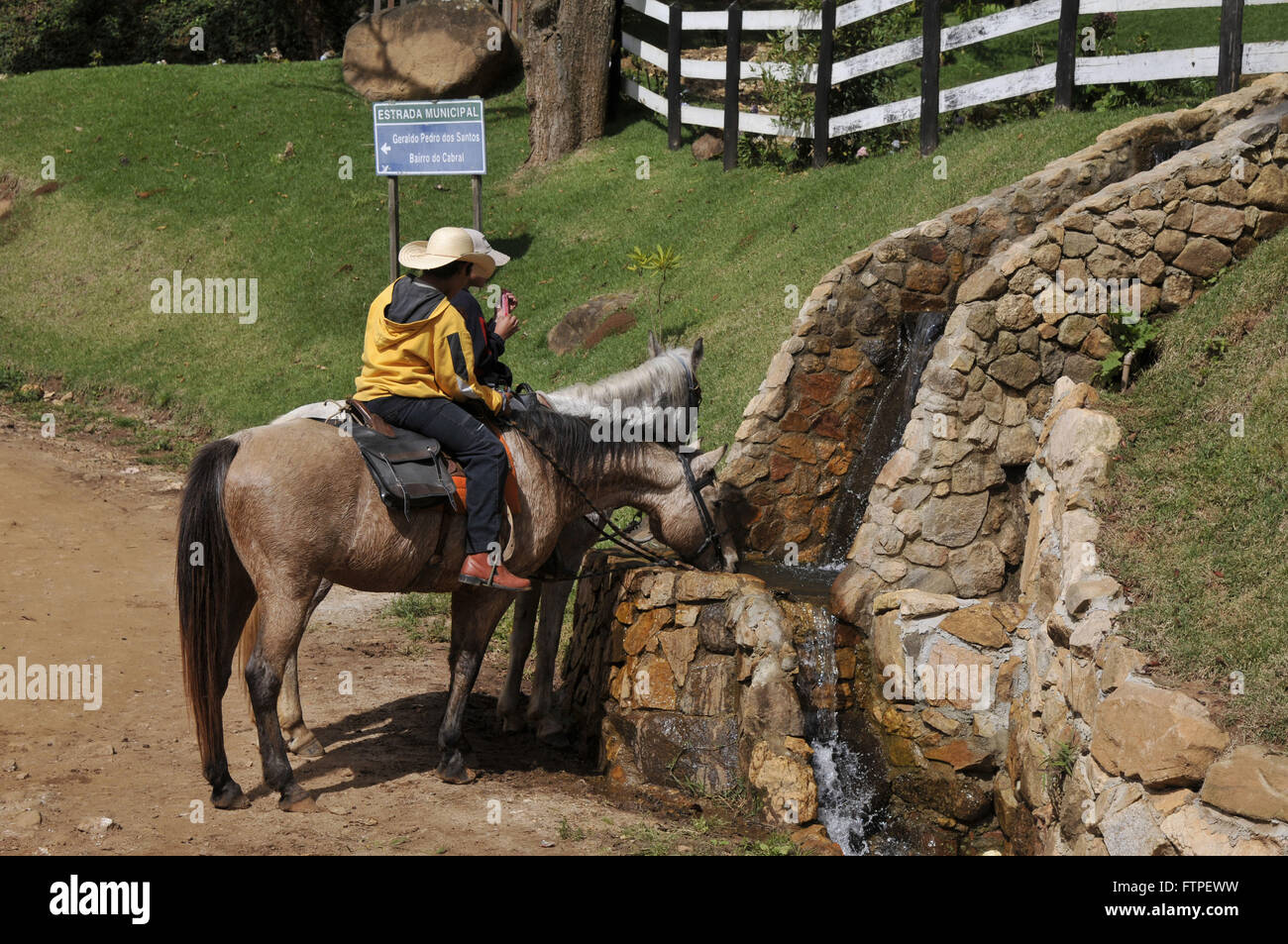 Reiter und Pferde im Chat Trinkwasser im Bezirk Abstellraum auf dem Lande Stockfoto
