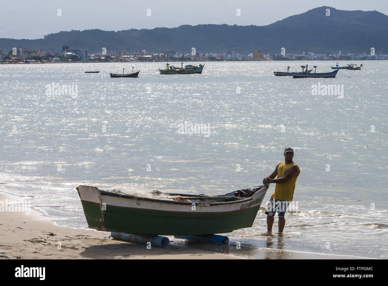 Fischer mit seinem Fischerboot am Strand Ingleses - britische Viertel von Rio Vermelho Stockfoto