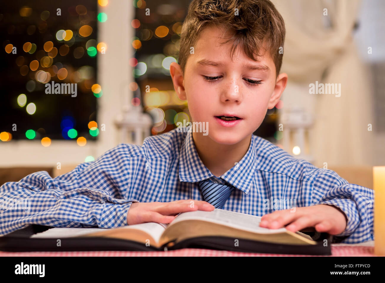 Junge liest ein dickes Buch. Stockfoto