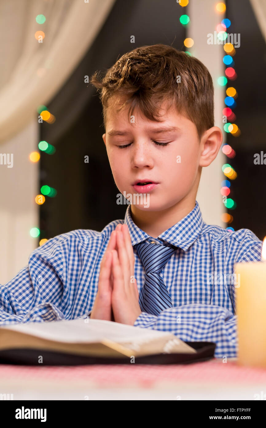 Junge am Tisch zu beten. Stockfoto