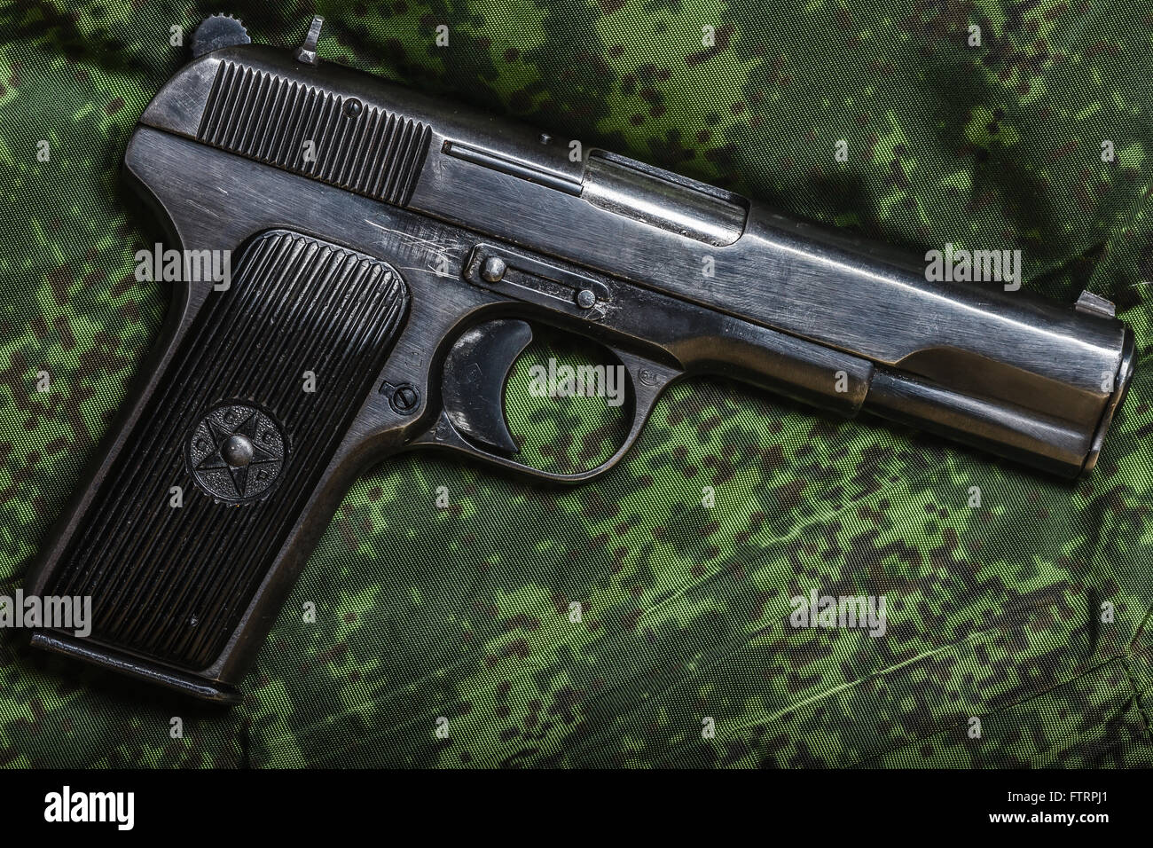 halbautomatische Pistole auf Pixel-Tarnung-Hintergrund Stockfoto