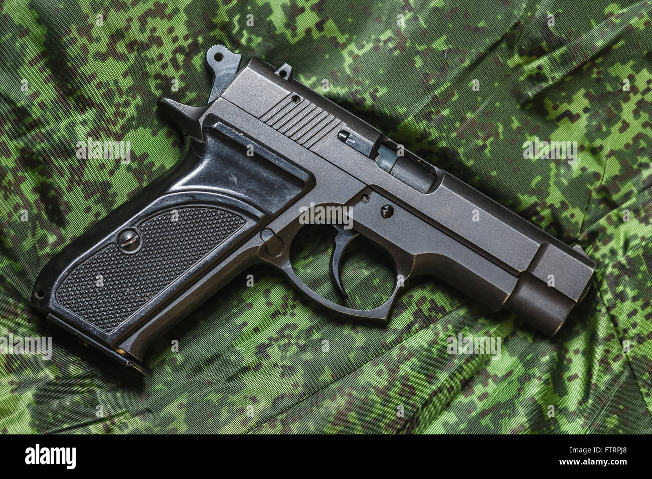 halbautomatische Pistole auf Pixel-Tarnung-Hintergrund Stockfoto