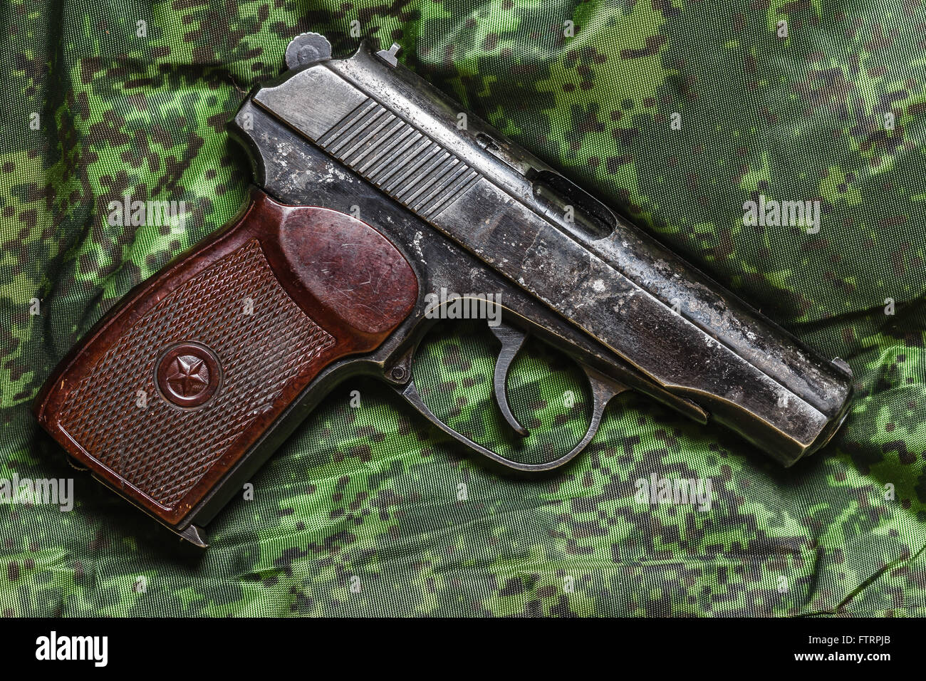 halbautomatische Pistole auf Pixel-Tarnung-Hintergrund Stockfoto