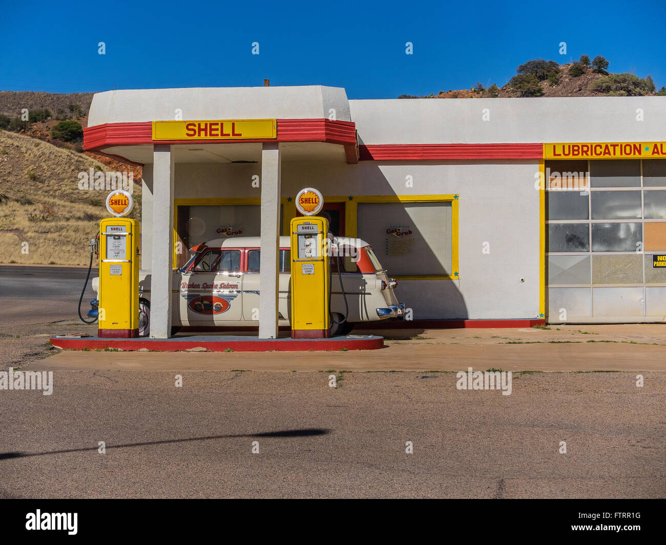 Klassiker der 1950er Jahre Shell-Tankstelle gelb lackiert und rot in Shell Farben und mit einer 1952 Ford Kombi geparkt vor. Stockfoto