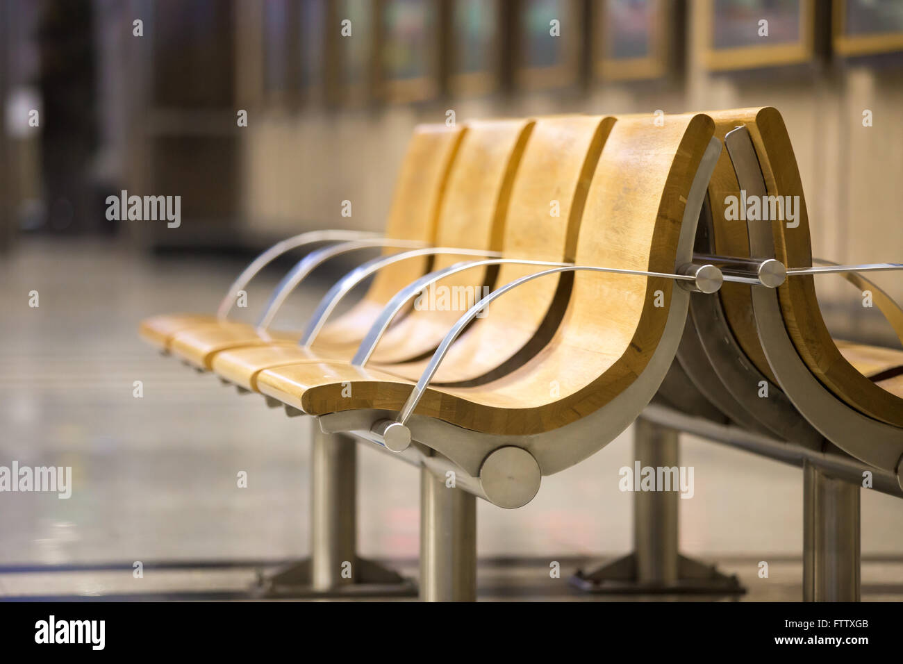 Linie der hölzernen leere Sitze im Wartebereich am Bahnhofsgebäude. Textfreiraum Stockfoto