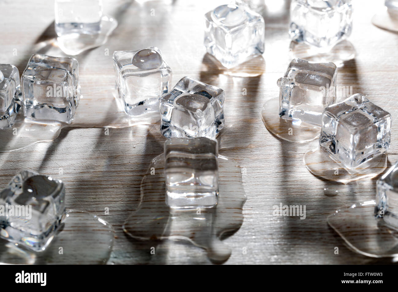 Kälte und Nässe Eiswürfel mit Hintergrundbeleuchtung auf Holztisch Stockfoto