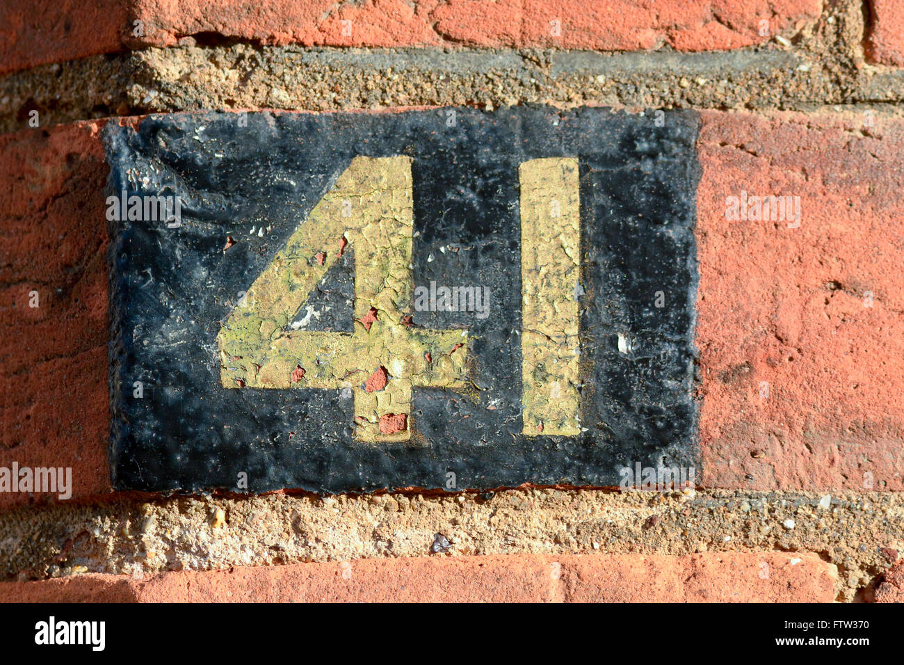 Hausnummer 41 Zeichen gemalt, Gold und schwarz auf roten Backsteinmauer Stockfoto