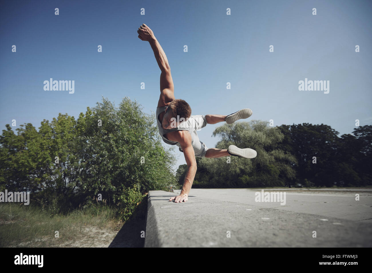 sportliche junge Mann springt im Sommerpark Stockfoto