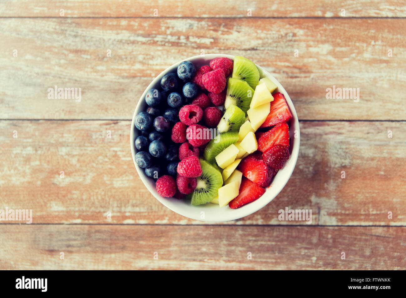 Nahaufnahme von Früchten und Beeren in Schüssel auf Tisch Stockfoto