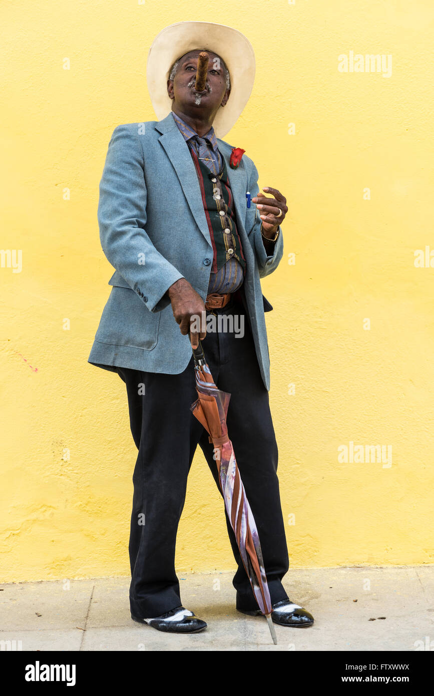 Havanna, Kuba - 27. September 2015: Traditionelle kubanische Mann große kubanische Zigarre rauchen auf gelbe Wand Hintergrund in Havanna, Kuba. Stockfoto