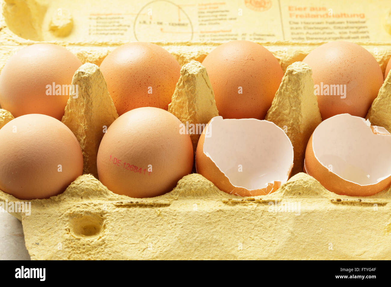 Eiern in einem Karton, einige ganz etwas rissig, mit Typenschild Stockfoto