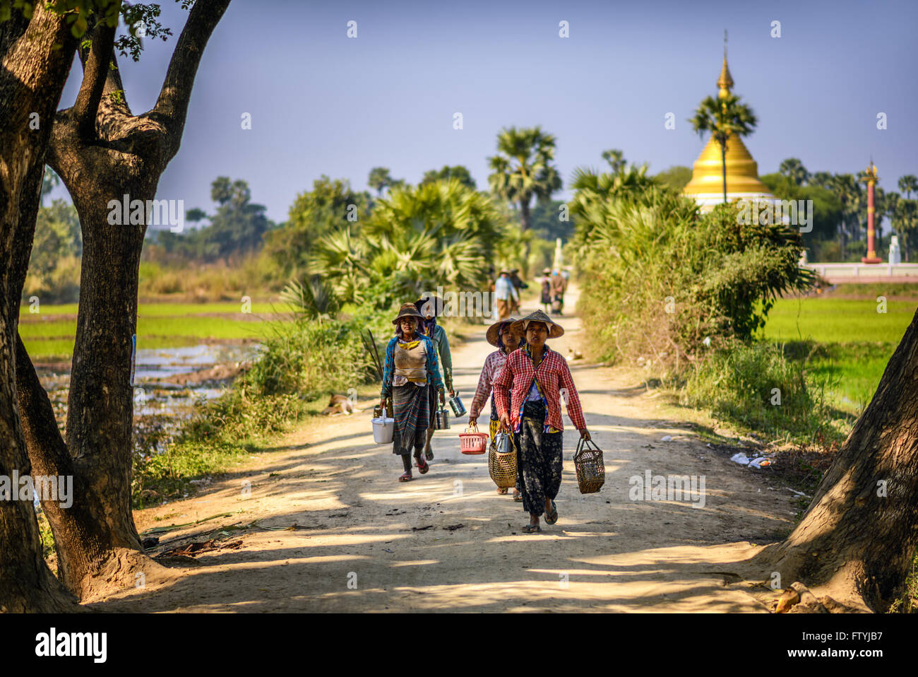 Bäuerin Arbeiter in traditionellen breitkrempige Strohhüte zu Fuß in der Nähe einer buddhistischen Stupa in Mandalay, Myanmar Stockfoto