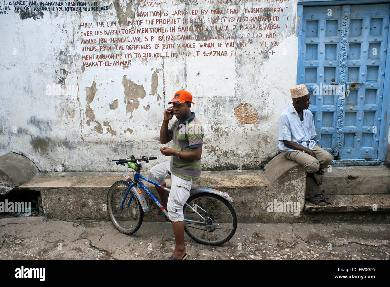 Einheimische und Fahrrad in einem der Stone Town s Labyrinth von engen Gassen, Sansibar, Tansania. Stockfoto