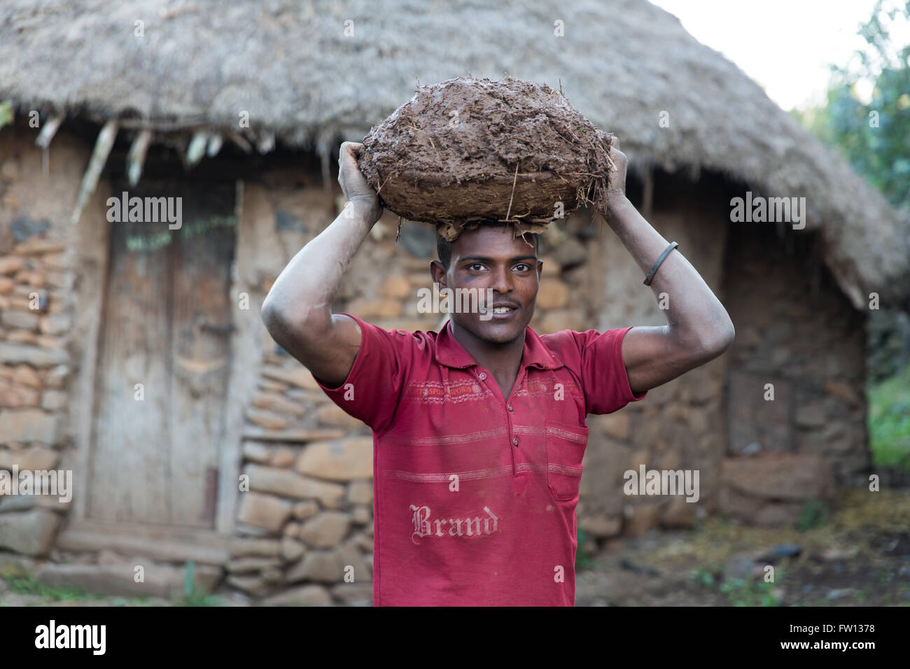 Debre Birhan, Amhara in Äthiopien, Oktober 2013: Teshome Nigerate, 22, trägt Schlamm um Alem bauen ein neues Haus mit Stein zu helfen. Stockfoto