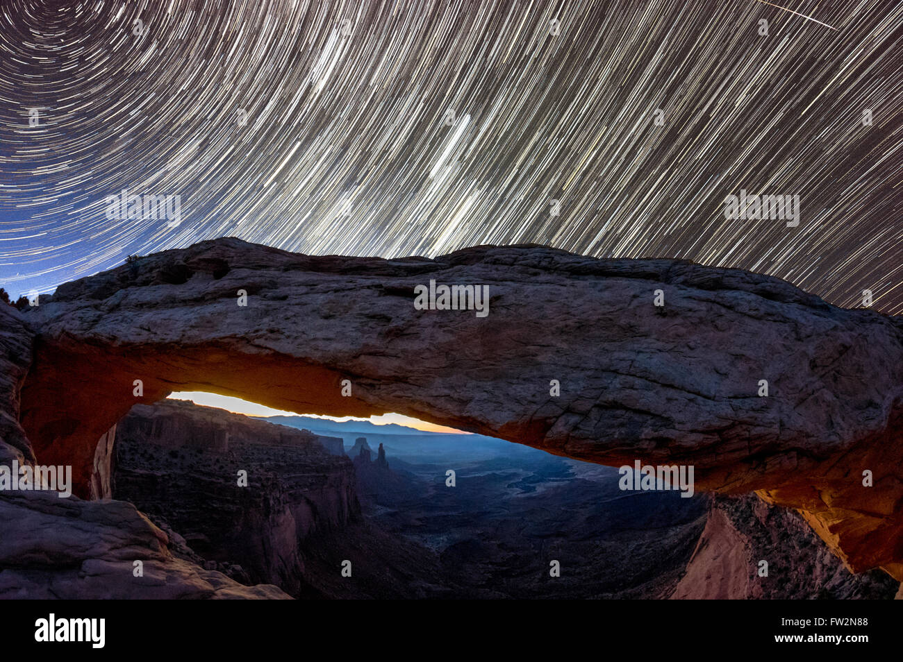 Sternspuren und ein Meteor erscheinen über Mesa Arch in der Nacht in Canyonlands Park in Utah. Stockfoto