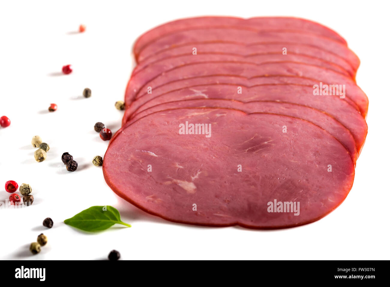 Frisch geschnittenes Rindfleisch Pastrami umgeben von Kräutern auf weißem Hintergrund Stockfoto