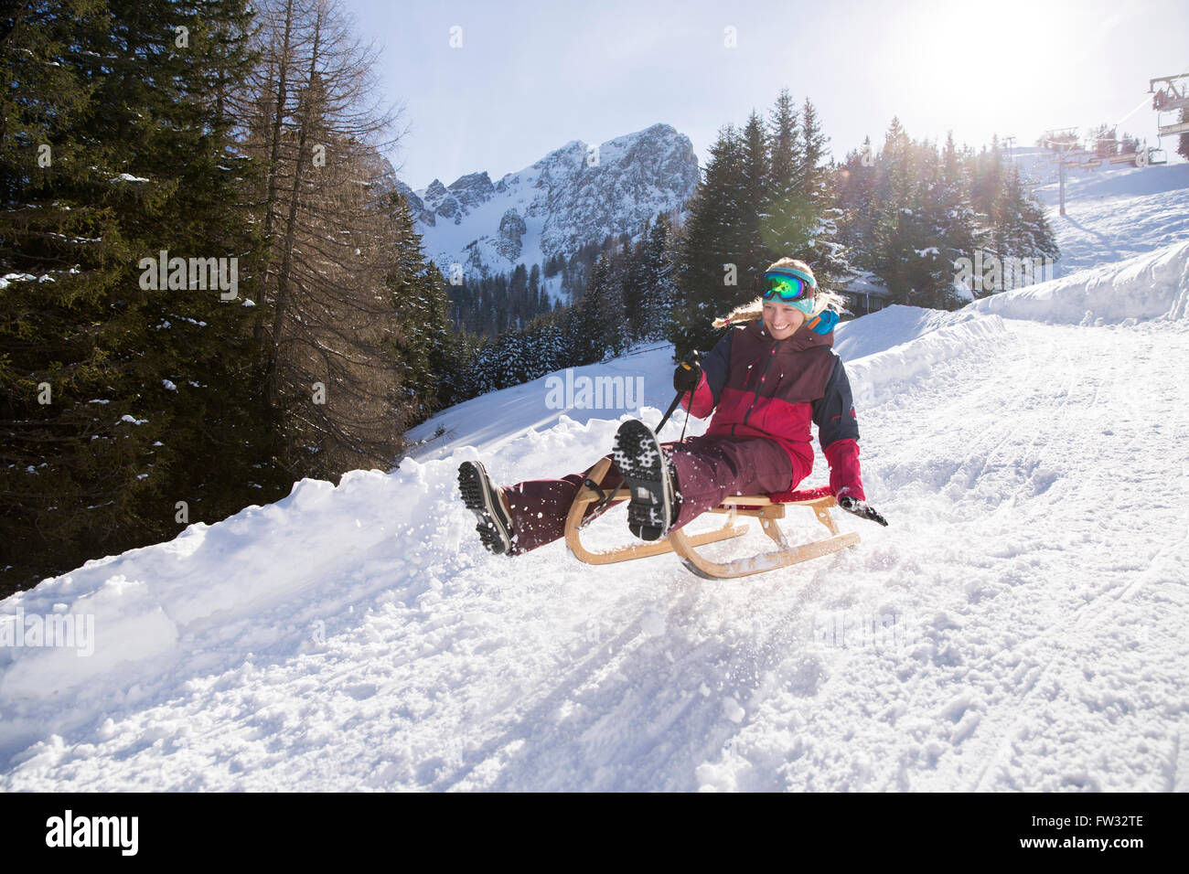Junge Frau auf einem Schlitten fahren, einen Sprung, Muttereralm-Innsbruck, Tirol, Österreich Stockfoto