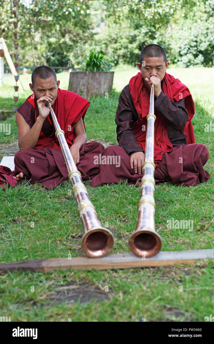 Mönche spielen tibetische Hörner, Tempe Tempel, Punakha Bezirk, Bhutan Stockfoto