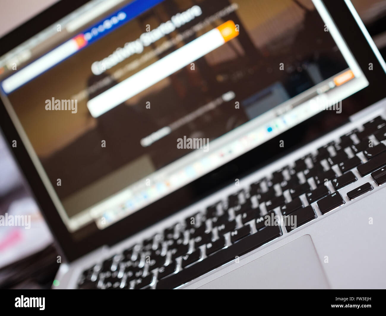 Laptop und unscharfen Website-Schnittstelle auf dem Bildschirm neigen Ansicht, geringe Schärfentiefe Stockfoto