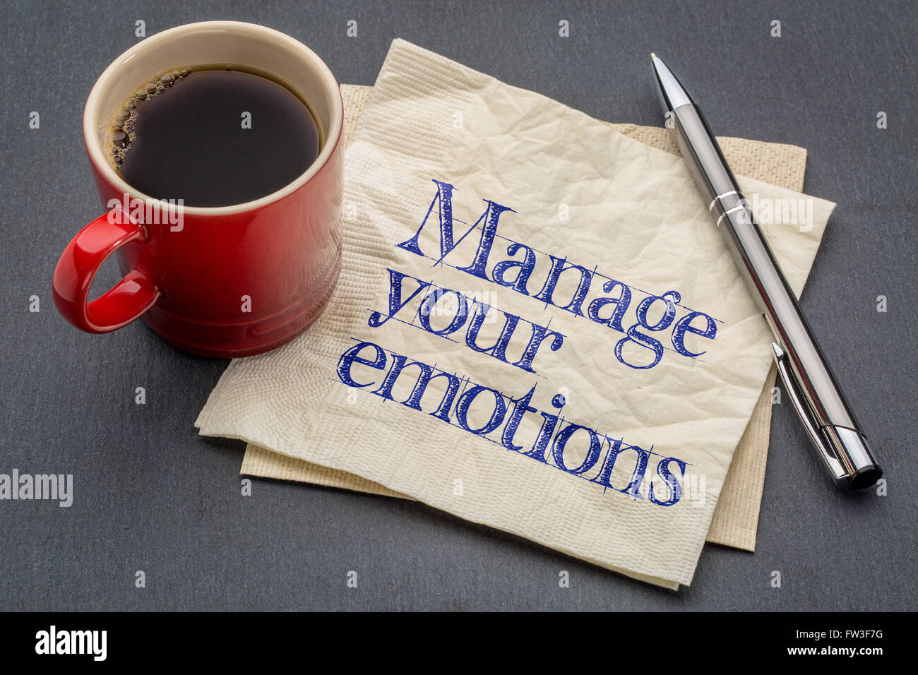 Verwalten Sie Ihre Emotionen Beratung oder Erinnerung - Handschrift auf einer Serviette mit Tasse Kaffee vor grauen Schiefer Stein Hintergrund Stockfoto