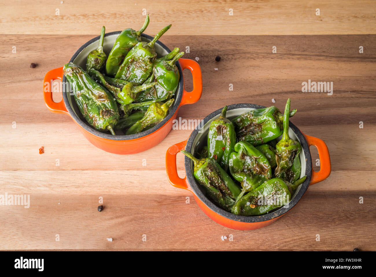 Padron gegrillte Paprika mit Salz und Pfeffer in kleinen Gusseisen Töpfe Stockfoto