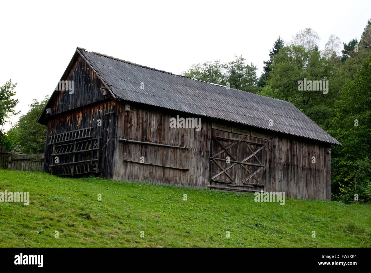 alte Holz Vintage Scheune auf einem Hügel mit Grass im Dorfmuseum Stockfoto