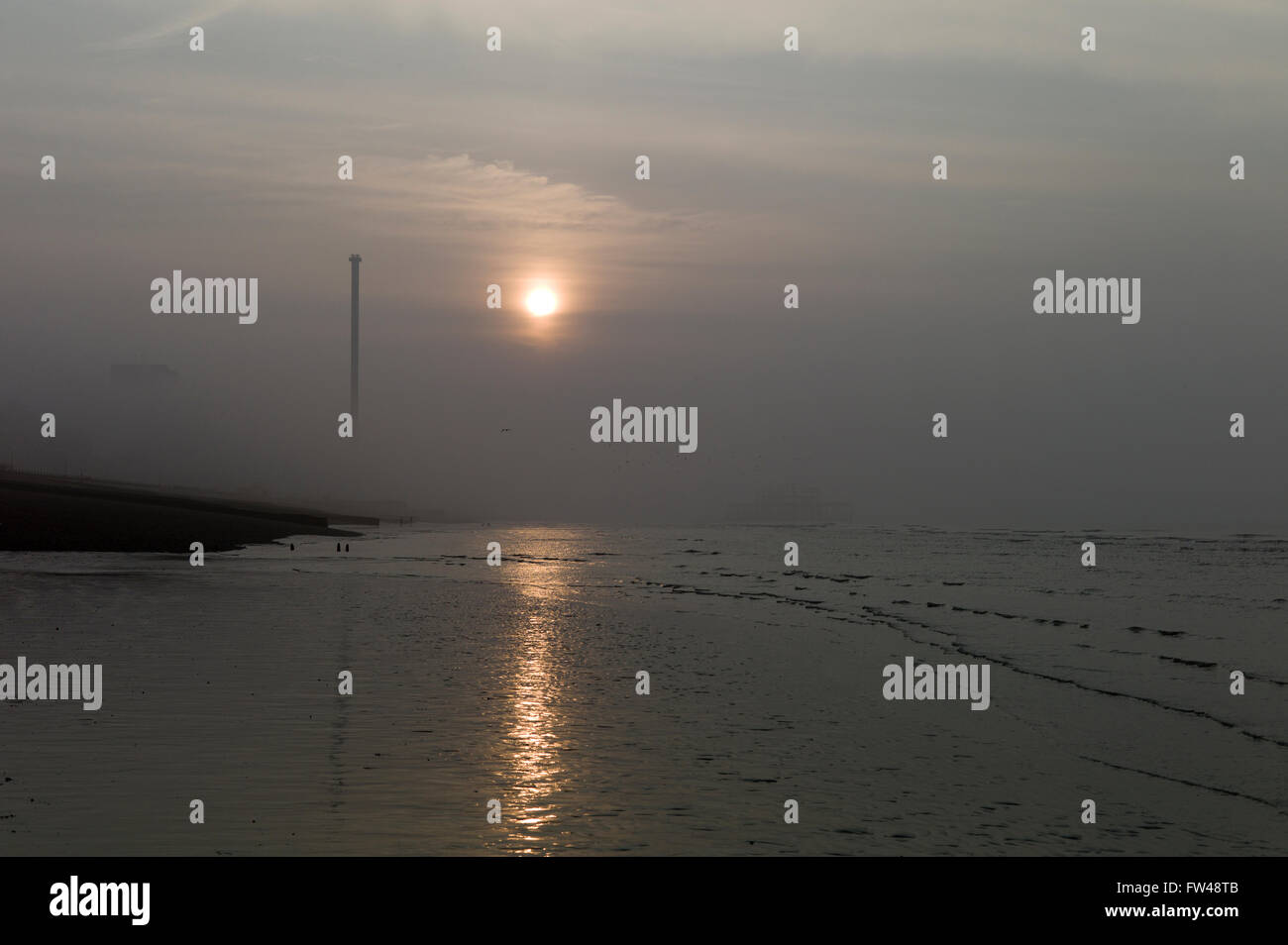 Sonnenaufgang am nebligen Morgen, Brighton Strandpromenade, mit verlassenen Pier West und i360 Aussichtsturm Stockfoto