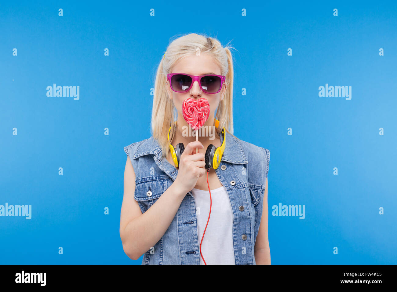 Stilvolle weibliche Teenager halten Lutscher über blaue backgound Stockfoto