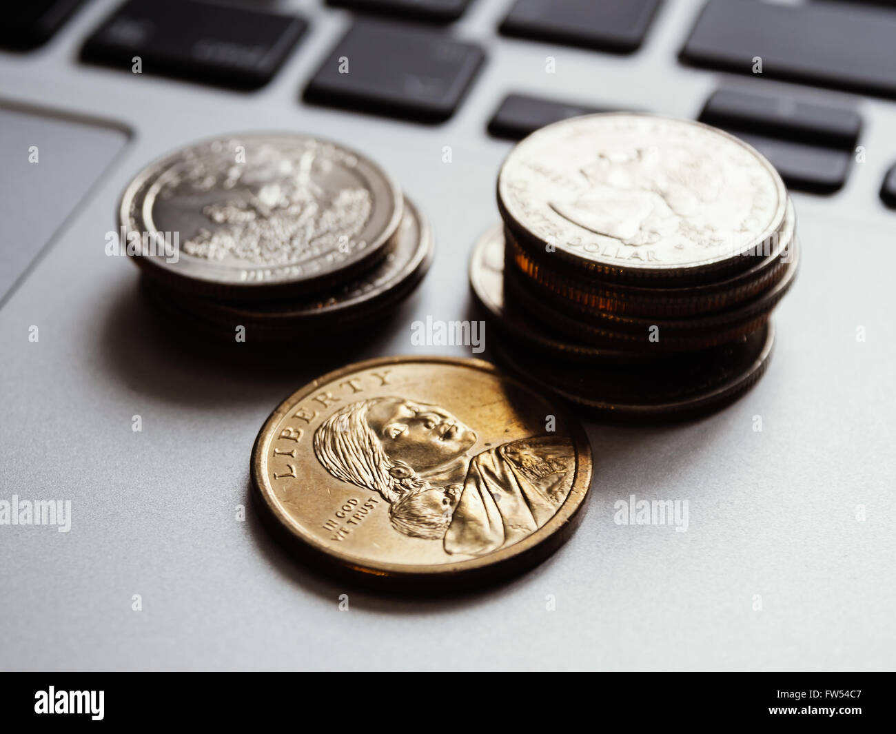 Hauswirtschaft - US-Münzen auf einer Laptoptastatur, geringe Schärfentiefe Stockfoto