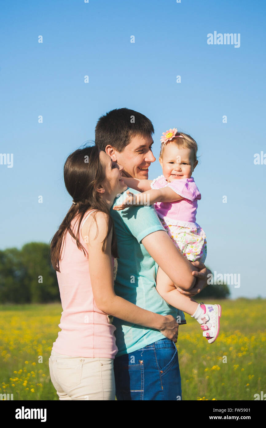 Familie mit drei Personen Spaß außerhalb. Vater ihrer kleinen Tochter in den Händen halten. Porträt von happy Family im blauen Himmel bac Stockfoto