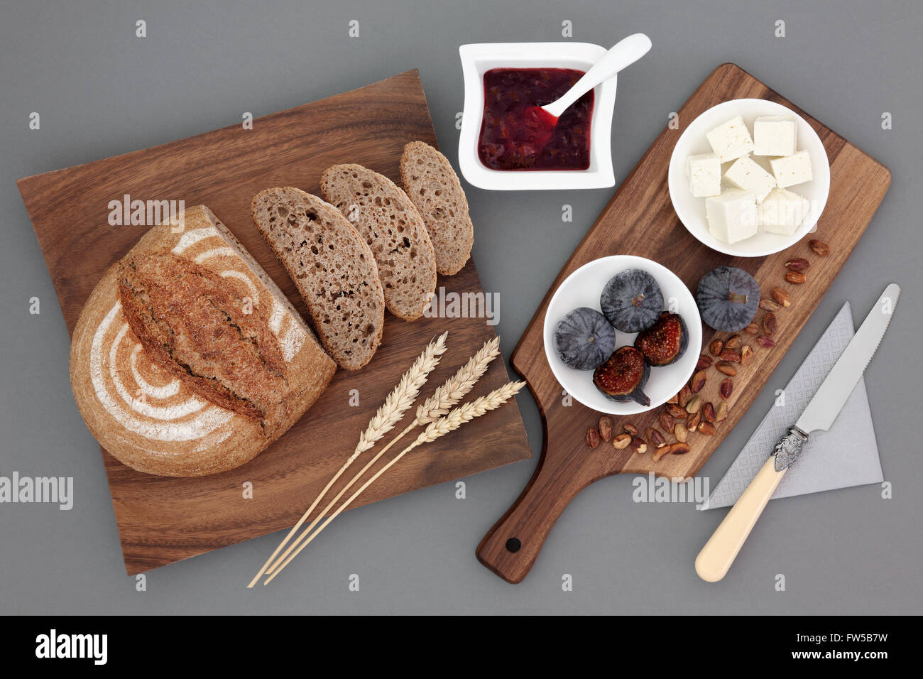 Rustikale griechische Snacks mit Feta-Käse, frische Feigen, roten Johannisbeeren Marmelade, Pistazien, Roggenbrot und Weizen scheiden. Stockfoto